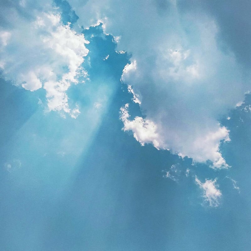 An image of the sky with sunlight coming through the clouds